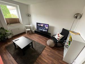 赫恩Wohnung in Herne Zentral mit Küche, Netflix, Disney Plus, DAZN的客厅配有桌子和电视