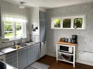 VejbystrandUnderbar havsutsikt på bjärehalvön的厨房配有水槽和微波炉