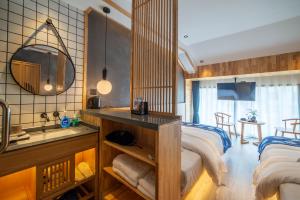 张家界Cozy Boutique Hotel的一间卧室配有床、水槽和镜子