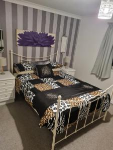 TonduRichlands Homestay的一间卧室配有一张带猎豹纹床单的床