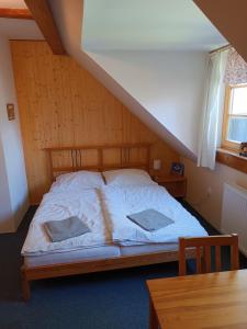 姆拉代布基Apartmány Mladé Buky的一张床上有两个枕头的房间