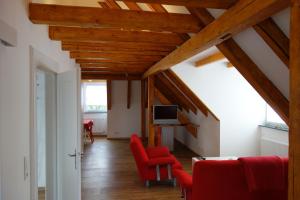 巴特基辛根Ferienwohnung & Wellness的客厅设有木制天花板和红色椅子