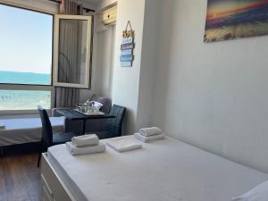 都拉斯Arteg Apartments - Full Sea View的客房设有床、桌子和窗户。