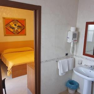 玛格丽塔萨沃亚瑞纳里餐厅酒店的一间带水槽的浴室和一间配有床铺的浴室