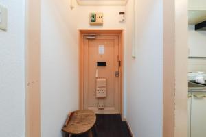 东京Grace Heiwajima的小房间,设有门和木凳