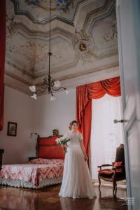 卢切拉爵床叶旅馆的身着婚纱的女人站在床前