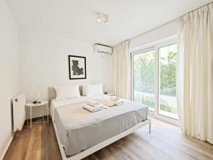 雅典Kalipsous Apartments by Verde Apartments的白色的卧室设有床和大窗户