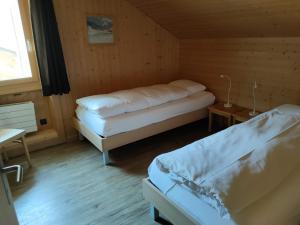 上瓦尔德富尔卡酒店的木制客房内的一间卧室配有两张床
