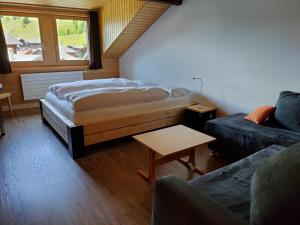 上瓦尔德富尔卡酒店的一间卧室配有一张床、一张沙发和一张桌子