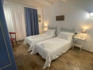 蒙基耶罗Antica Cascina Pilo的一间卧室配有两张床、一张桌子和一把椅子