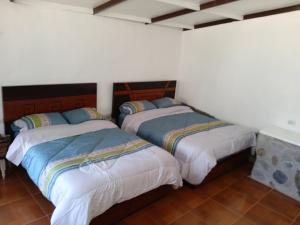 瓦拉斯casa montañista lodge & camping的白色墙壁客房的两张床