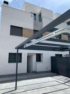 马德里Acogedora casa en Madrid con piscina privada, jacuzzy y garaje的白色砖砌建筑,设有黑色车库