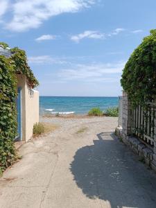 帕拉塔蒙Niki Apartments Beach Loft的一条土路,一条带栅栏的土路通往大海