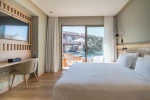 赫索尼索斯SENSEANA Sea Side Resort & Aquadventure的一间卧室配有一张床、一张书桌和一个窗户。