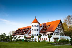 魏森贝格Golfhotel Bodensee的一座白色的大建筑,有橙色的屋顶