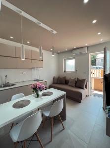 蒂瓦特Mavalux apartments的厨房以及带桌椅的起居室。