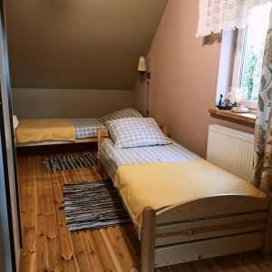 Przejma WielkaDomek letniskowy Ali的客房内设有两张床,铺有木地板,设有窗户。