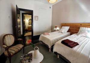 阿尔比Maison d'Hôtes " L'INSTANT D'AILLEURS"的一间卧室配有两张床、一把椅子和一张桌子
