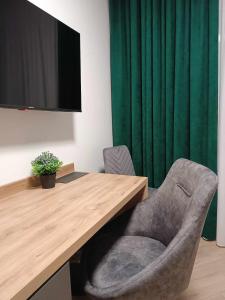 卢布林地区亚努夫Apartamenty Centrum的一张桌子、椅子和一台电视机