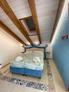阿杰罗拉Bed&Breakfast Miramare的一间卧室设有蓝色的床和木制天花板
