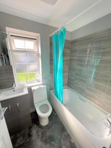 米查姆Lilleshall Rooms的浴室配有卫生间、浴缸和水槽。