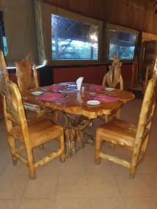 NarokMasai Mara Explore Camp的一张带两把椅子的木桌和一张带盘子的桌子