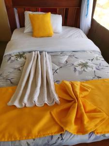 NarokMasai Mara Explore Camp的床上有黄色和白色的毯子