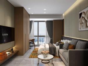 东莞Shi Lai De Executive Apartments的客厅配有床和沙发