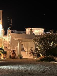 马鲁焦Casa alle Colonne的一座白色的大房子,晚上有楼梯