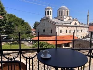 普里兹伦Treva Hotel的一个带教堂的阳台的桌椅