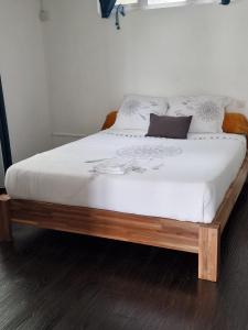 马埃堡Le Manguier的一张带白色床单和枕头的床