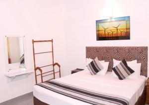 尼甘布Cozy Inn Negombo的一间卧室配有一张床和镜子