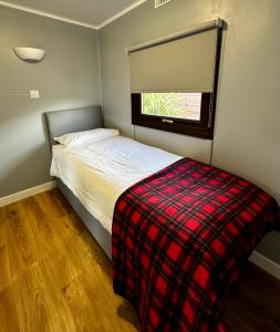 波特帕特里克Lagavulin 3的一间小卧室,配有床和窗户