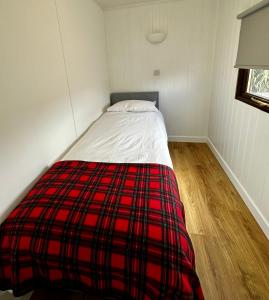 波特帕特里克Lagavulin 3的一张床位,房间里配有红色和黑色的毯子