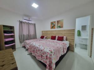 阿拉卡茹Sobrado a 200m da Praia e Orla, 02 QTS com ar condicionado的一间卧室配有两张带红色枕头的床