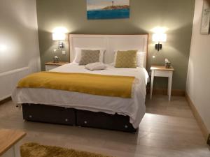 朗德斯通Quayside luxury apt Roundstoneselfcatering的一间卧室配有一张大床和两张桌子
