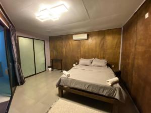 刁曼岛Pondok Beach Shack的一间卧室设有一张床和木墙
