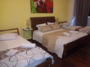 萨尔瓦多卡尔穆精品一室公寓酒店的一间卧室设有两张床,墙上挂着一幅画