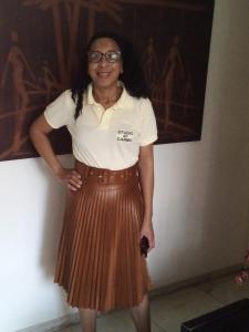 萨尔瓦多卡尔穆精品一室公寓酒店的穿着白色衬衫和棕色裙子的女人