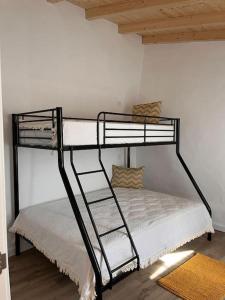 阿尔奇瓦Alqueive GUEST HOUSE的白色的带梯子的客房内的一张黑色双层床