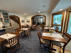 布恩Lovill House Inn的一间带桌椅的餐厅,以及楼梯