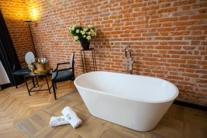 克拉科夫HOTEL TEATR的砖墙客房内的白色浴缸