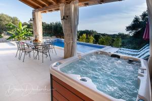 伦Island Villa Adriana with heated pool and sauna的庭院内的热水浴池,配有桌椅