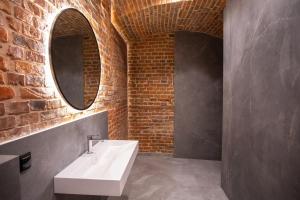 克拉科夫HOTEL TEATR的一间带白色水槽和砖墙的浴室