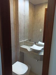 圣洛伦索Loft Centro - No Calçadão e em frente Parque das Águas的浴室设有卫生间和带镜子的盥洗盆