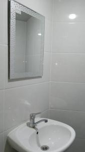 撒马尔罕Begzod's house的浴室设有白色水槽和镜子