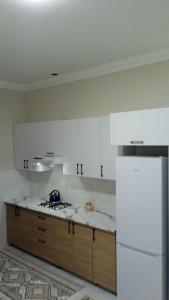 撒马尔罕Begzod's house的厨房配有白色橱柜和白色冰箱。
