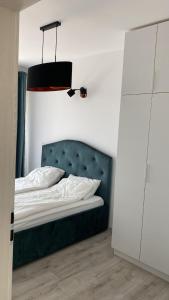 弗洛雷什蒂Columna residence的一间卧室配有一张带绿色床头板和灯的床。