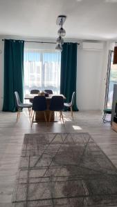 弗洛雷什蒂Columna residence的用餐室配有桌椅和绿色窗帘