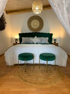 圣路易斯Lepetitcoinenchante的一间卧室配有一张带两张绿色椅子的床